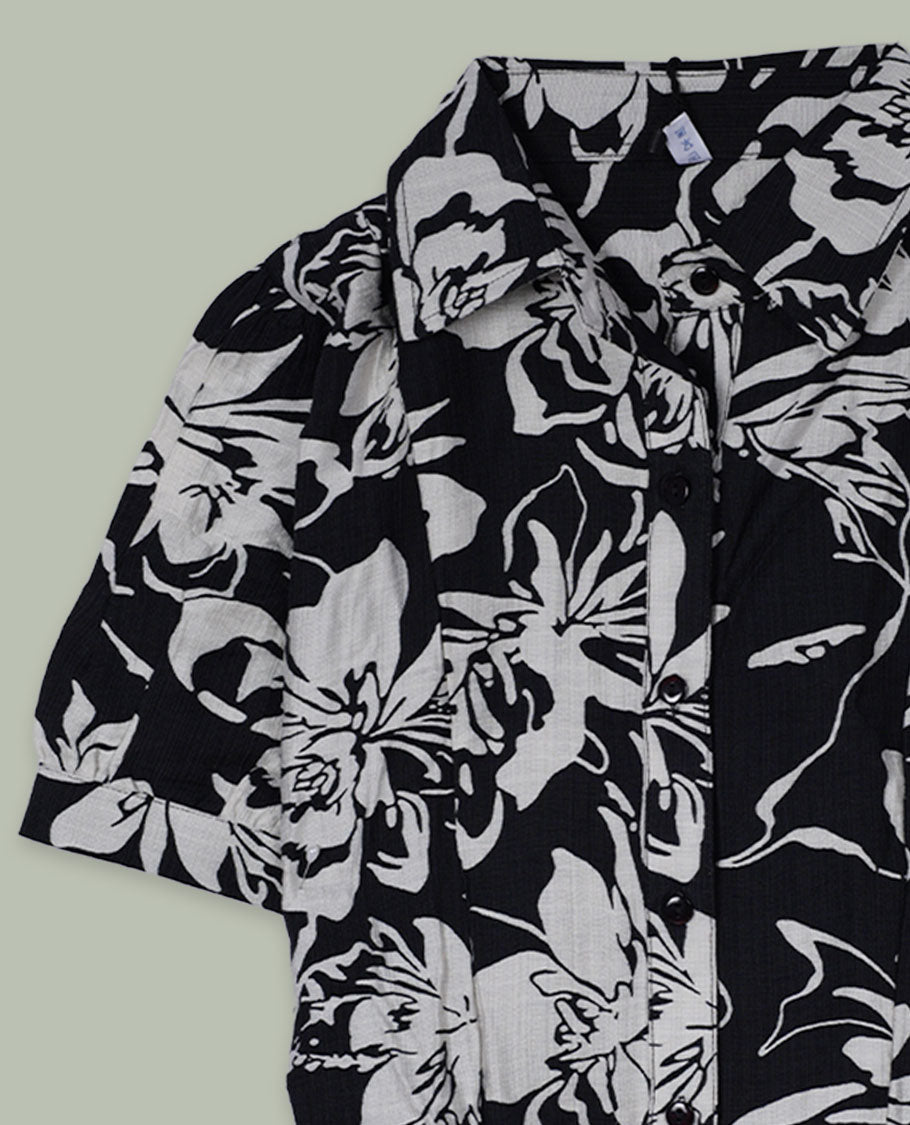 Black and white floral printed short-sleeve shirt top with collared neckline, front button placket, and softly gathered shoulders.
