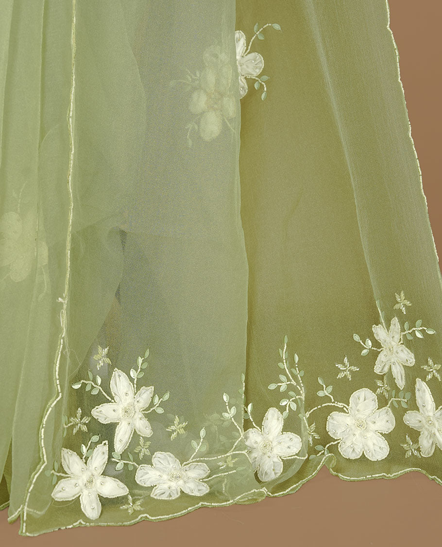 Pastel olive colour crush organza saree featuring white floral work with beats & sequins, highlighting scalp with beats worked border, paired with matching blouse piece.
