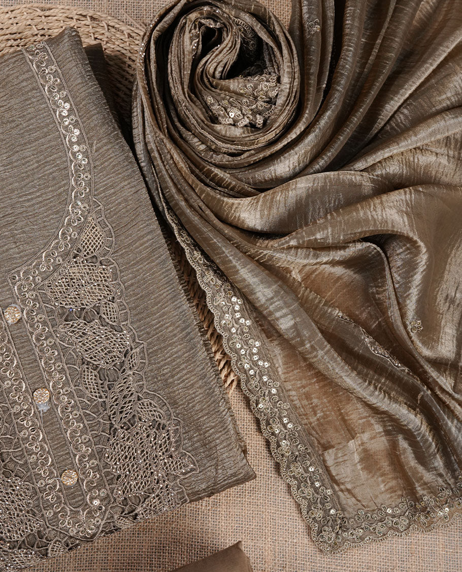 Taupe brown churidar suit material with lace embroidery and subtle sequin detailing on the neckline, paired with a matching textured dupatta and plain bottom.