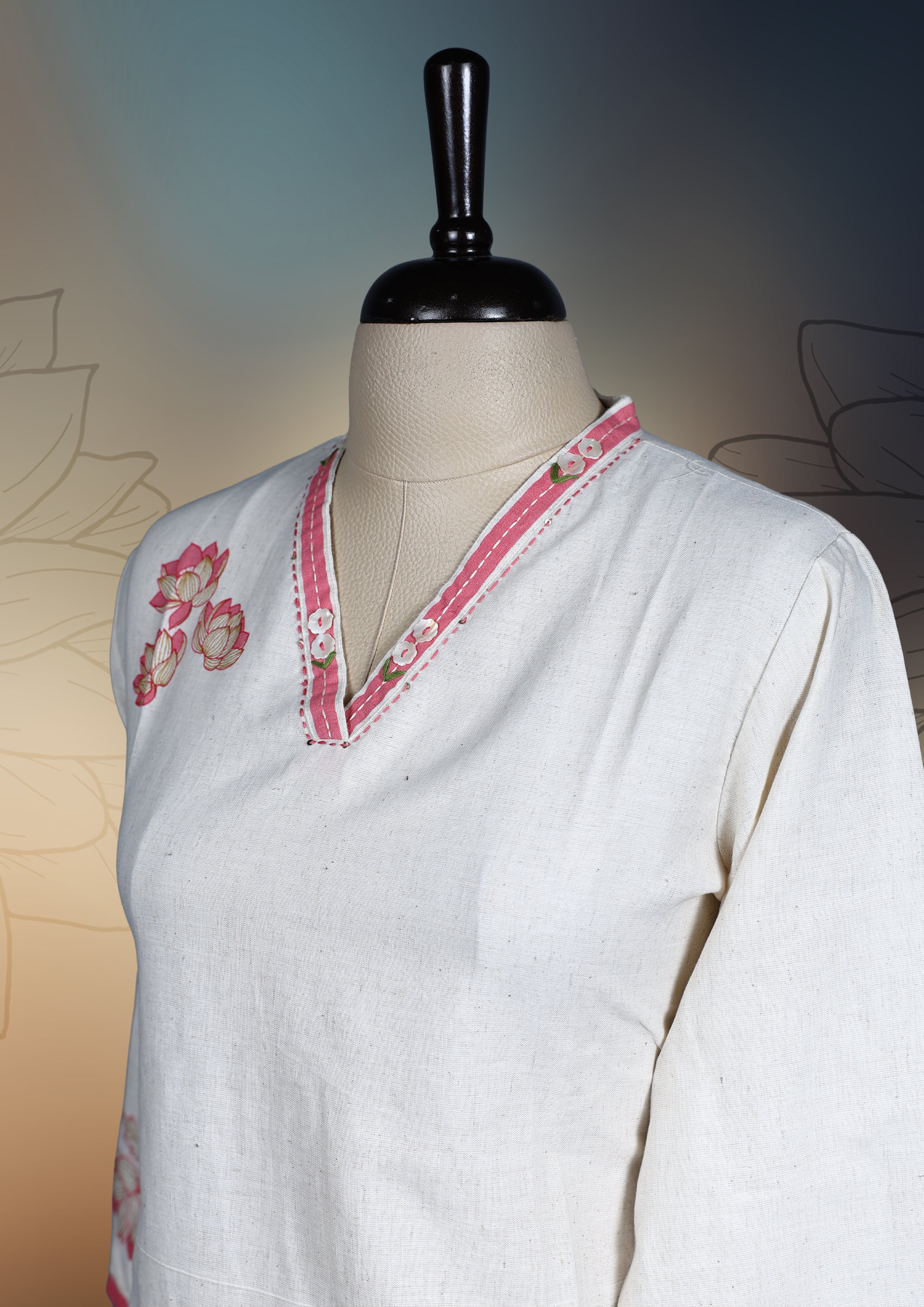 Off white colour kurthi with delicate pinkish peach floral embroidery on the neckline, sleeves, and hem, Featuring a stylish V neck and three quarter sleeves, perfect for a graceful and comfortable look.