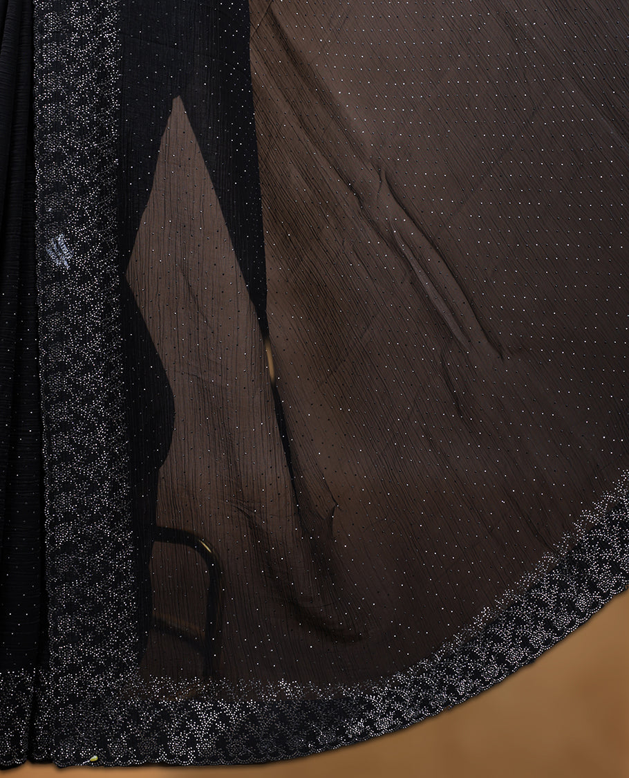 Black colour chiffon designer saree, featuring white stone all over on body, heavy stone patttern on border and pallu, Paired with matching blouse.