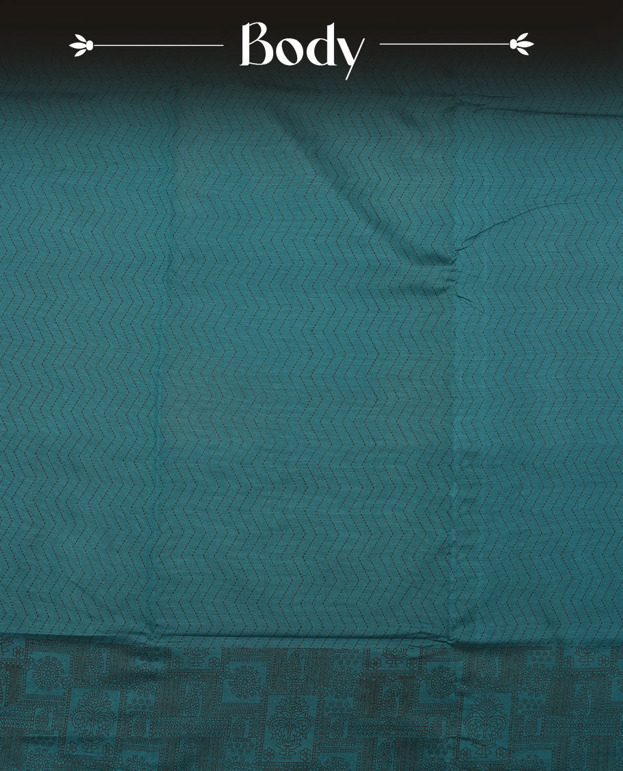 Dark Teal Green colour poly cotton saree with black zigzag line pattern on the body, paired with a matching pallu featuring black chevron lines and panelled floral‑paisley design, and a coordinated all‑over floral paisley patch‑style printed blouse piece.