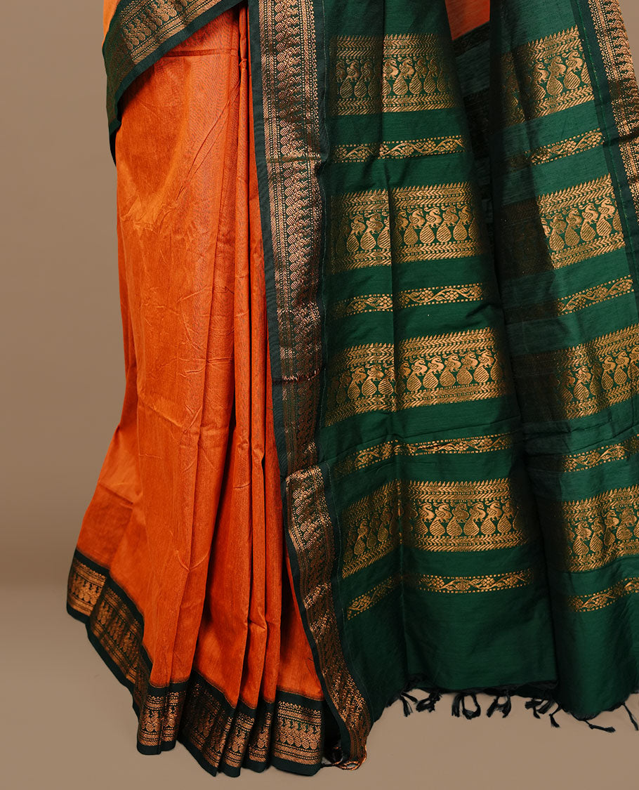 Rust orange colour kalyani cotton saree featuring gold zari motifs on body, complemented by green colour with zari border, paired with matching blouse piece.