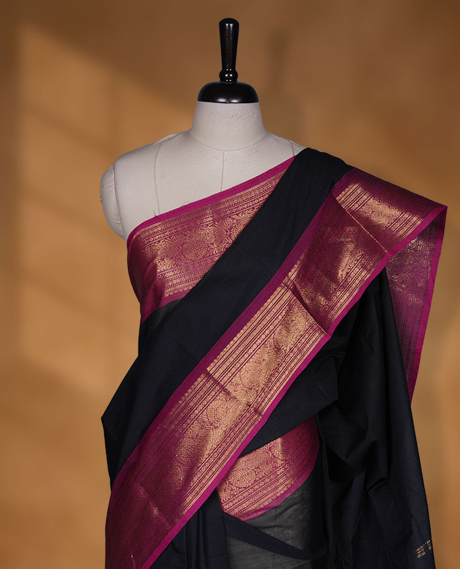 Black colour chettinad cotton saree featuring elegant plain body highlighting contrast magenta colour with gold zari traditional border, pallu and paired with matching blouse piece.