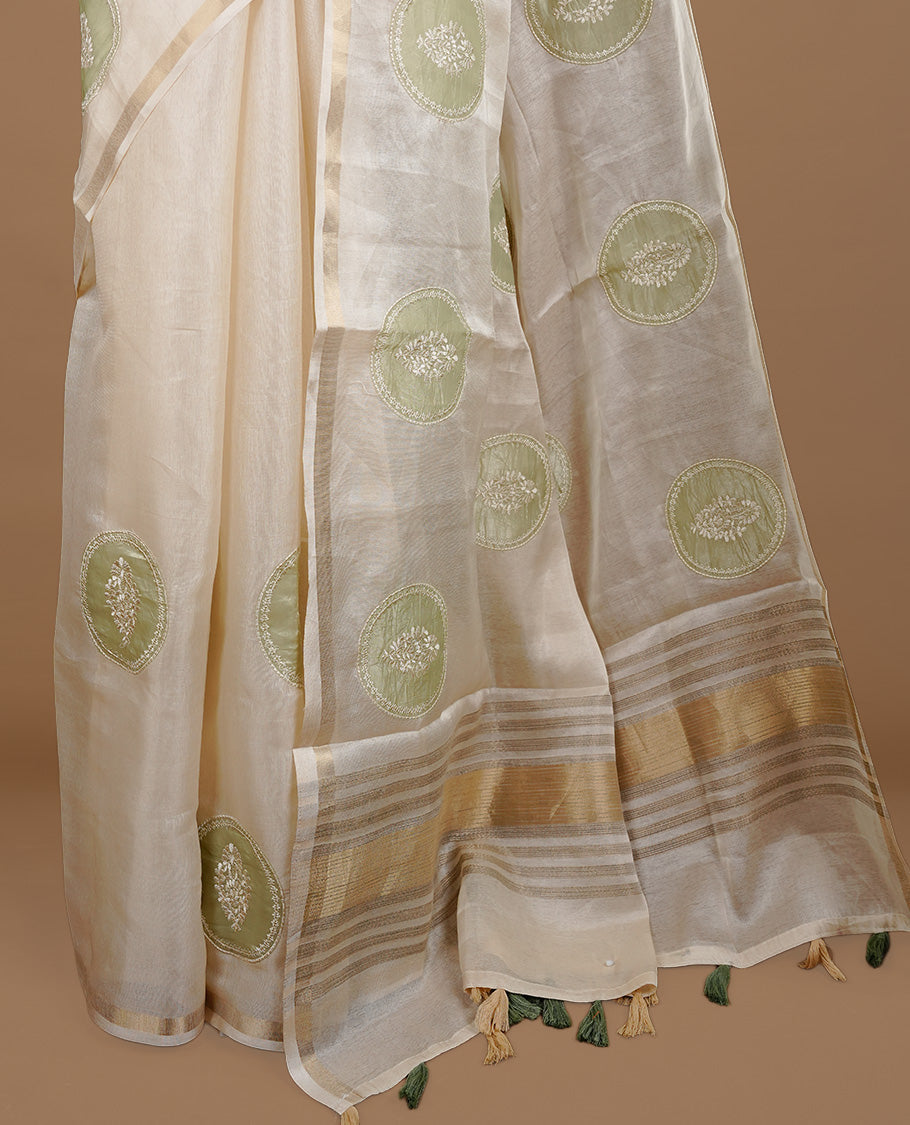 Cream colour Tussar saree featuring green colour circle pattern with chikankari embroidery work, highlighting gold zari simple border, paired with matching unstitched blouse.