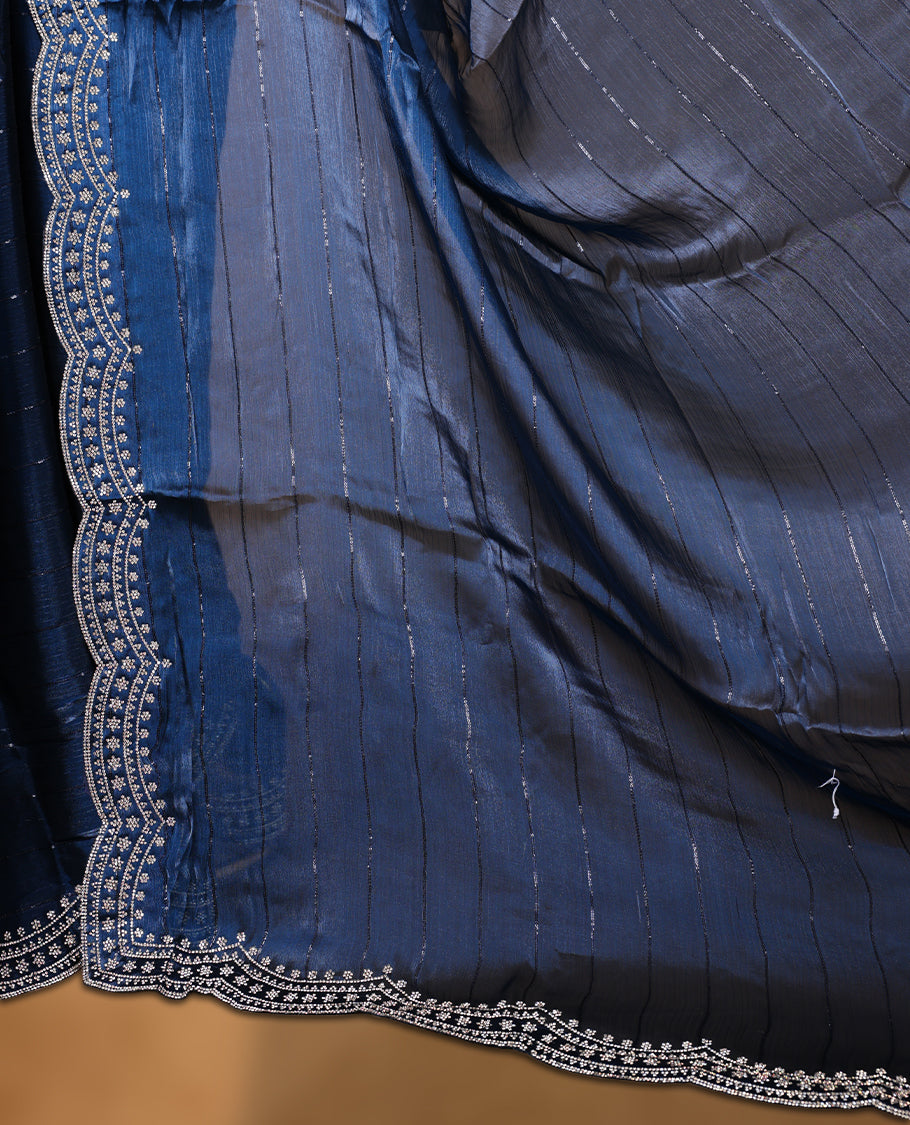 Dark blue colour chiffon designer saree, featuring self colour beats stripes on body, heavy gold stone patttern on border and pallu, Paired with matching blouse.