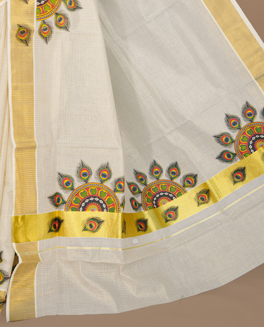 Off white color kerala cotton saree featuring gold zari check on body, complemented by, gold zari with peacock leaf printed border, paired with matching blouse piece.