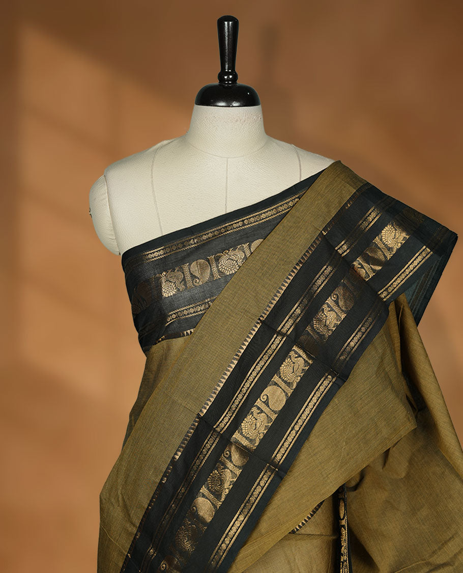 Olive Drab colour chettinad cotton saree featuring plain body, paired with a black colour traditional gold zari border paired with matching blouse.