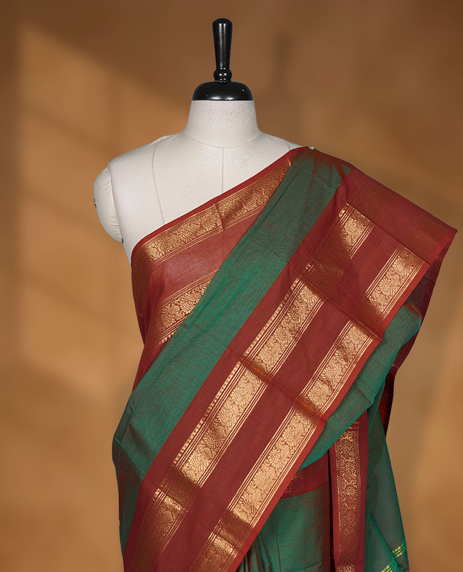Dark Green colour chettinad cotton saree featuring Elegant plain body, contrast Red colour border with gold zari border, pallu and paired with matching blouse.