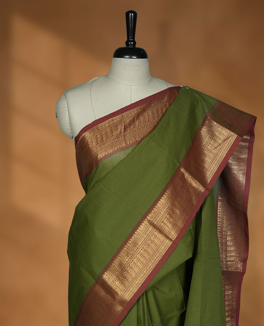 Olive green colour chettinad cotton saree featuring Elegant plain body, contrast Brick red colour border with gold zari border, pallu and paired with matching blouse.