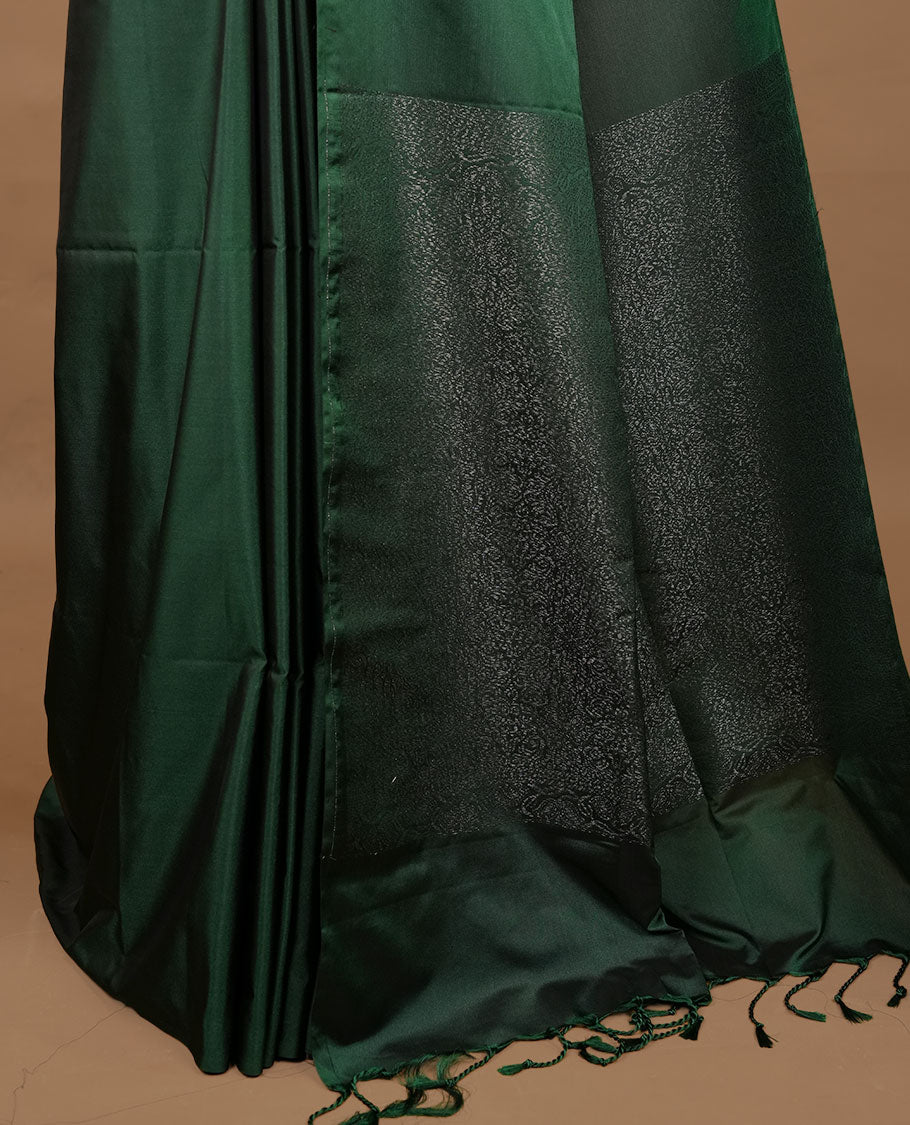 Green soft silk saree features a sleek borderless design with intricate antique zari motifs, flowing into a seamless self colored pallu and a matching blouse piece.
