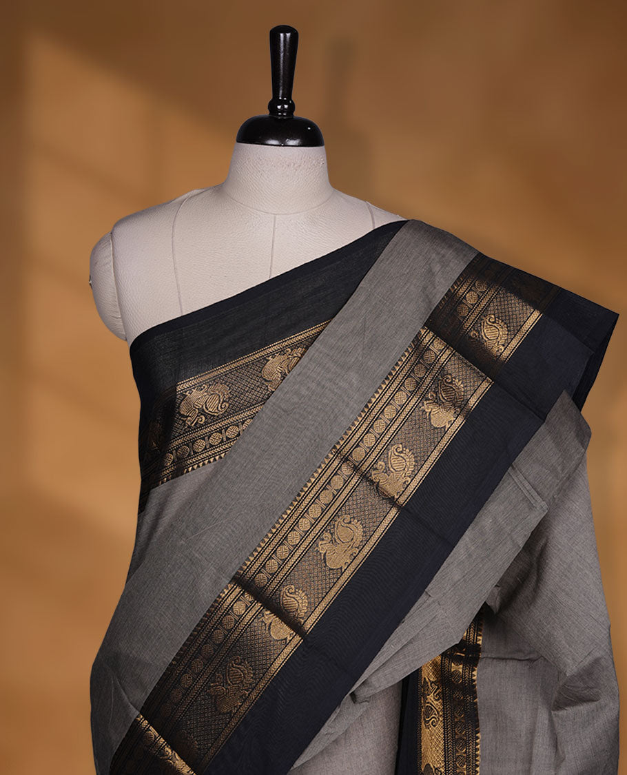 Beige grey colour chettinad cotton saree featuring plain body, contrast black colour with traditional gold zari border without blouse.