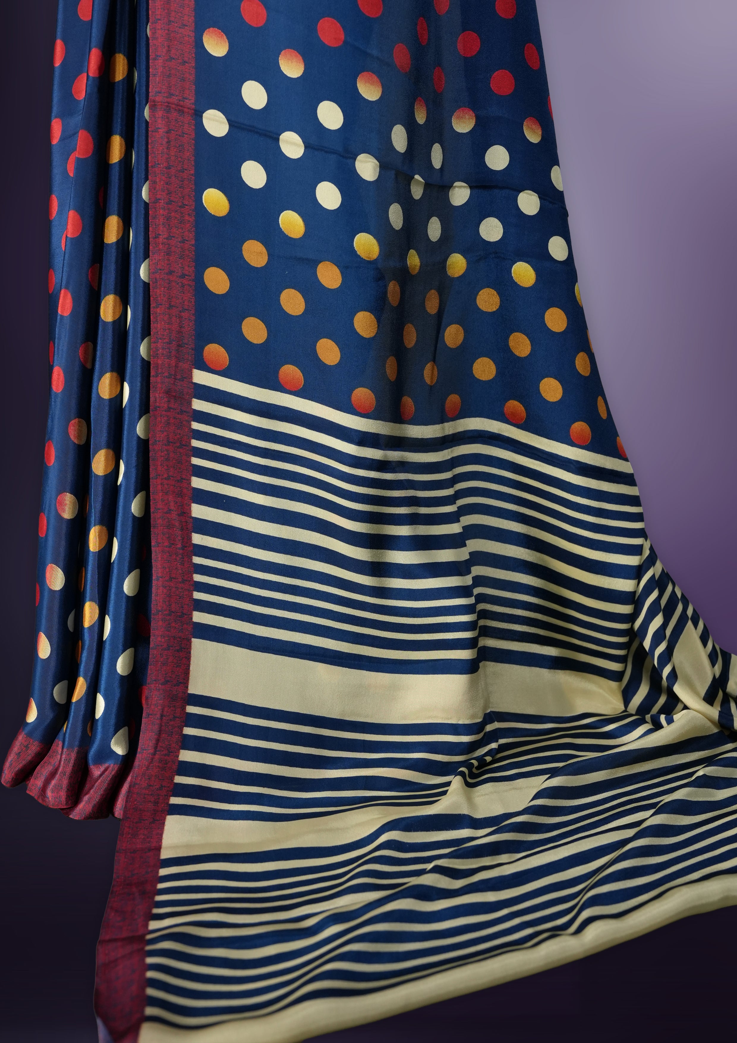 Blue colour saree with red, white & yellow motifs, diamond border, and bold pallu & Comes with a paired matching blouse.