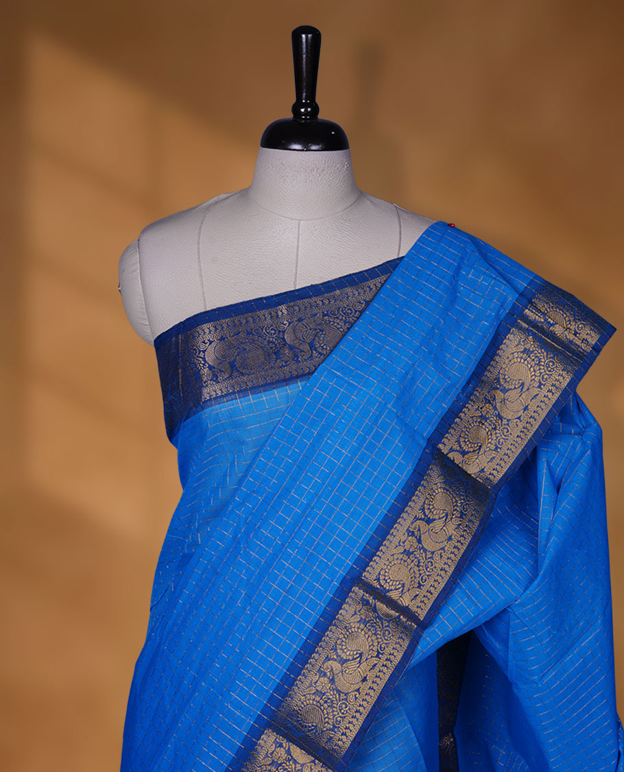 Blue colour chettinad cotton saree featuring gold zari check patterned body, paired with a dark blue colour traditional gold zari border without blouse.