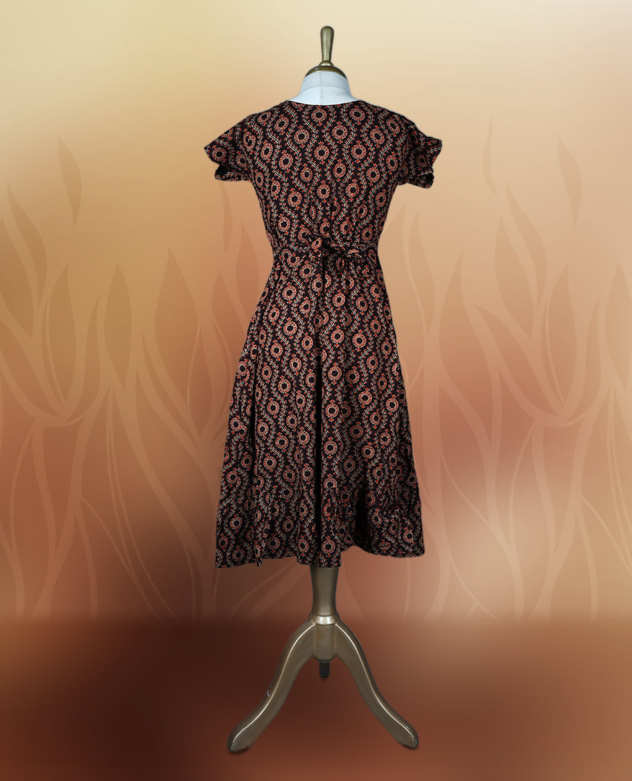 Brownish black colour nightwear with an elegant red and beige ethnic print, Features a flattering V neck, short sleeves, and a flared hem, Ideal for casual outings, festive gatherings, or comfortable daily wear.