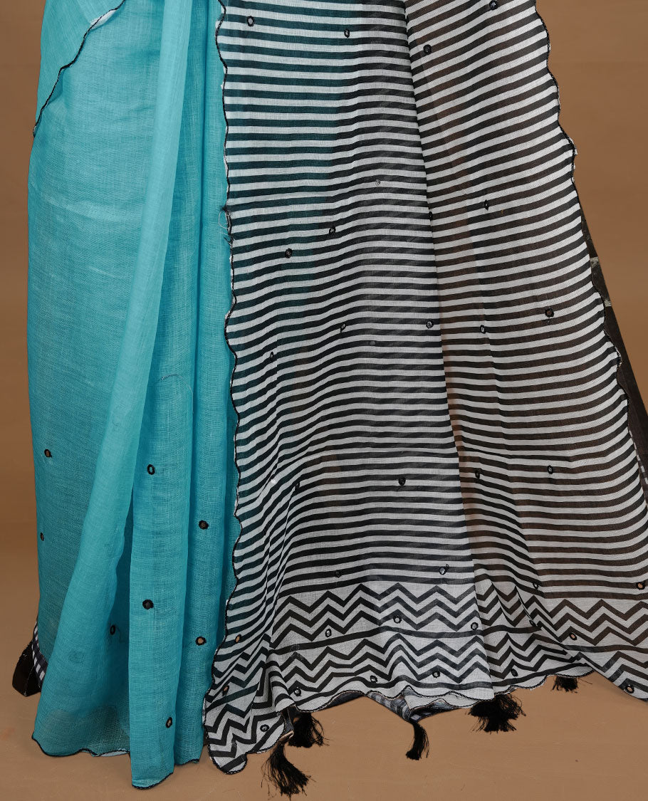 Aqua colour Semi Linen saree featuring mirror work with intricate thread detailing, enhanced by a stylish scallop border. Comes without a blouse piece.