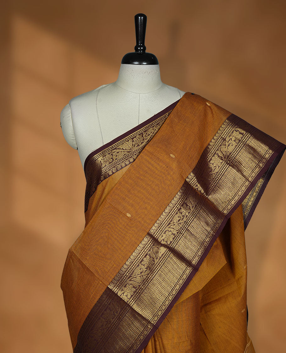 Mustard colour chettinad cotton saree featuring gold zari colour motifs on body, contrast purple colour border with gold zari border, pallu and paired with matching blouse.