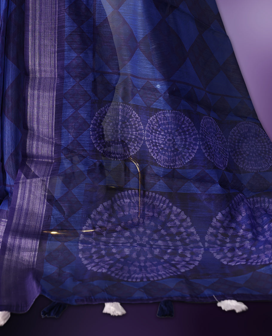 Blue saree adorned with geometric woven patterns across the body, accentuated with a subtle striped border, and a pallu featuring circular motifs with delicate tassel detailing, paired with a matching blouse.