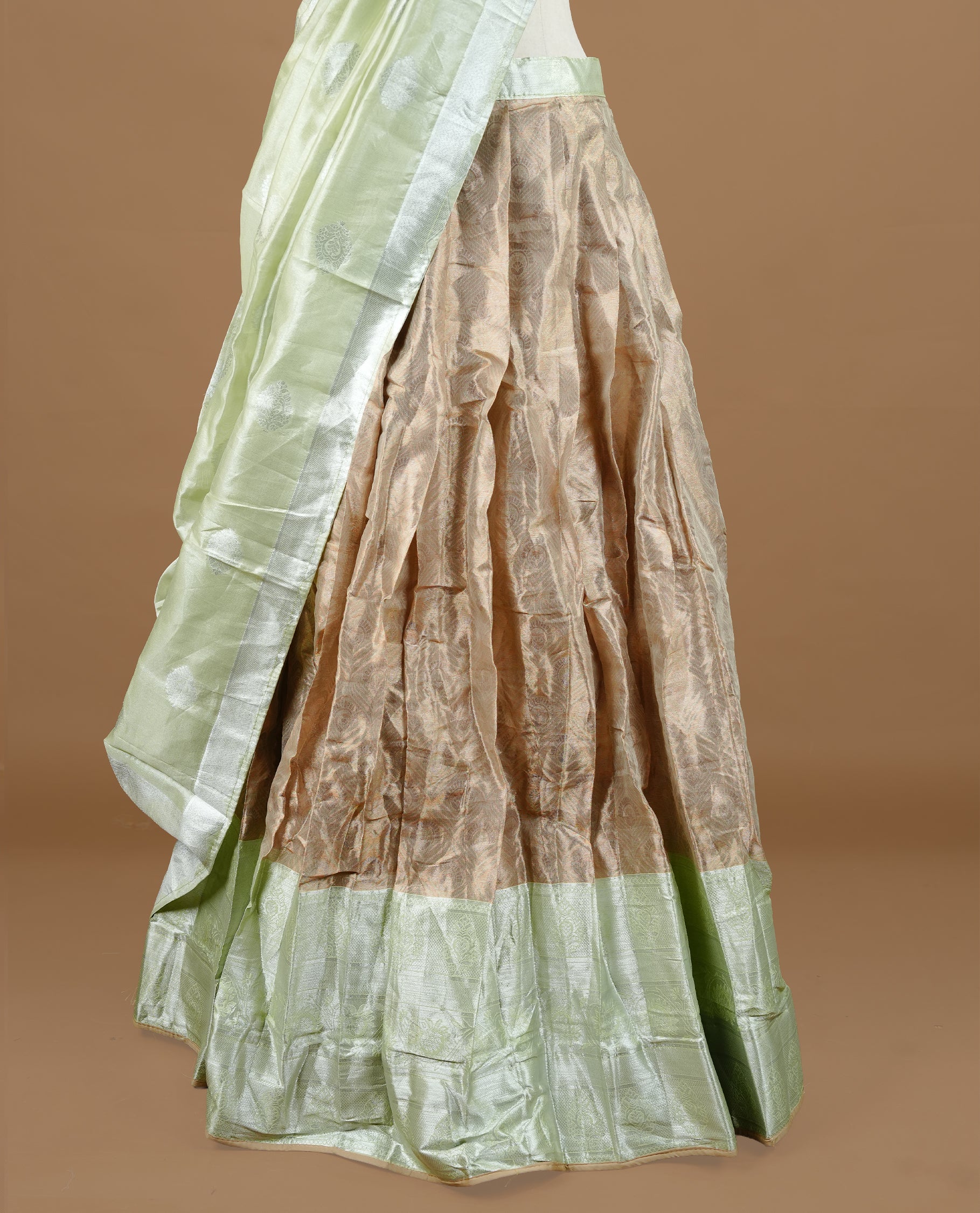 Pastel green colour Half saree featuring Antique colour skirt with contrast dusted gold colour border, paired with matching stitched blouse piece, with matching dupatta.