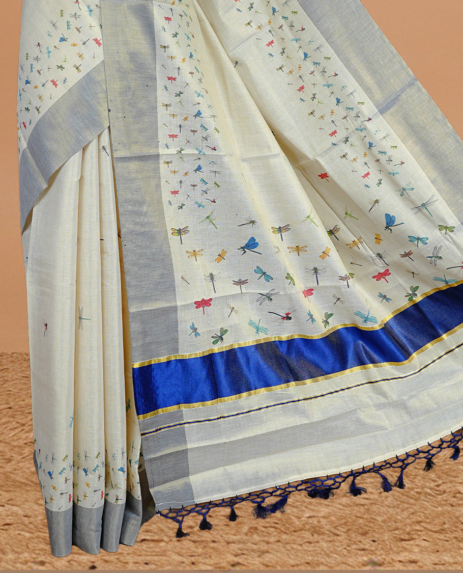 Cream Colour Tissue Kerala Saree Featuring Plain Body ,Complemented By Blue Zari With Dragonfly Printed Border ,Enhance By A Blue With Gold Zari Pallu ,Paired With A Matching Blouse Piece.