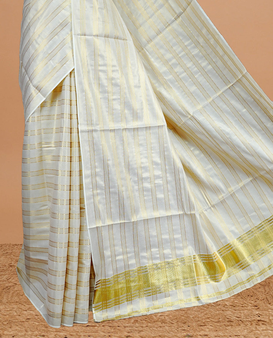 Cream Colour Tissue Kerala Saree Featuring Classy Gold zari stripes on Body, Enriched By Gold Zari Border, Paired With A Matching Blouse Piece.