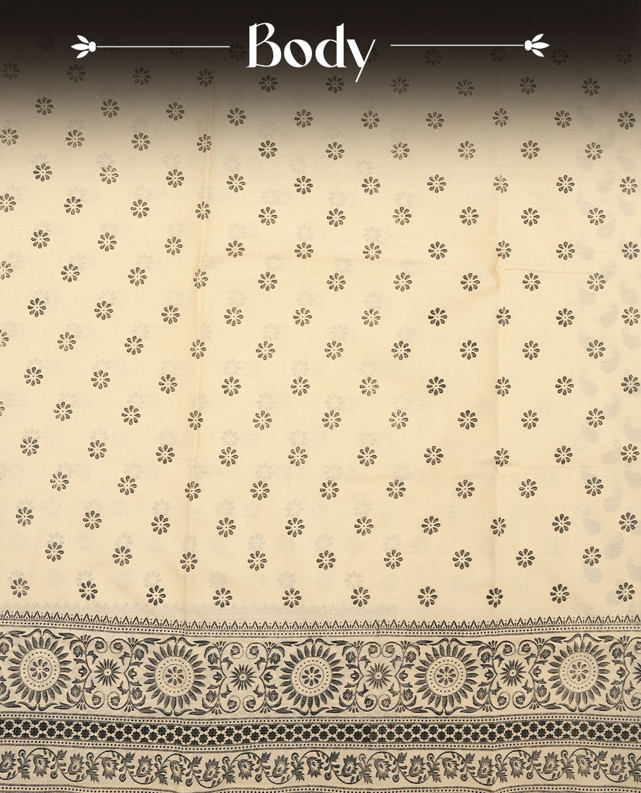 Cream colour poly cotton saree with black floral butti motifs on the body, paired with a matching pallu featuring black ornate floral jaal and stripes on the border, and a coordinated all‑over black paisley printed blouse piece.