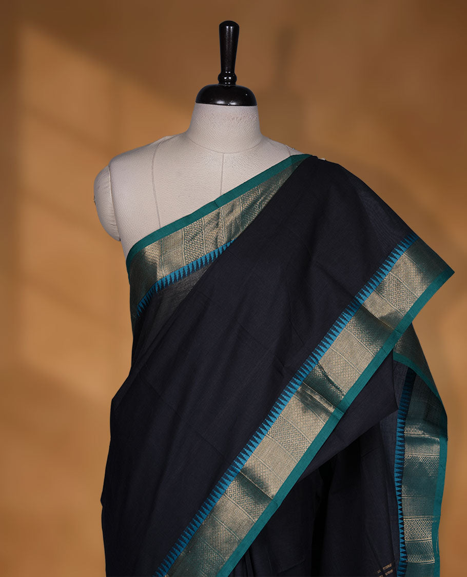 Black colour chettinad cotton saree featuring Elegant plain body highlighting contrast green colour colour with gold zari traditional border, pallu and paired with matching blouse piece.