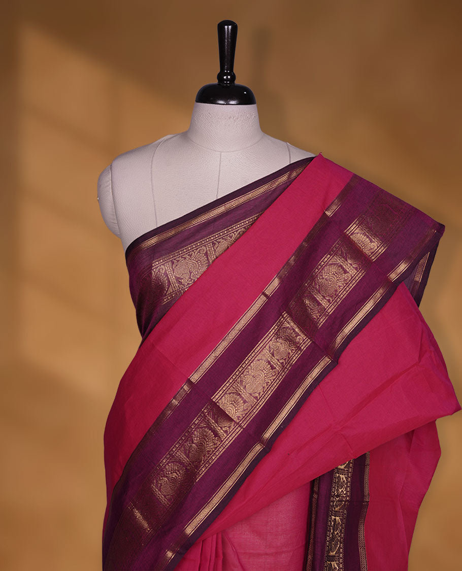 Rani pink colour chettinad cotton saree featuring plain body, contrast burgundy colour with traditional gold zari border paired with matching blouse.