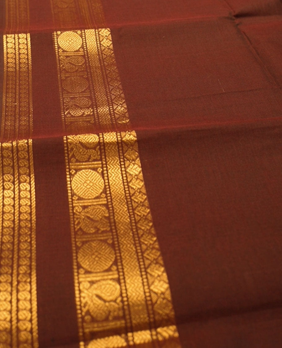 Mono-tone Coffee brown colour chettinad cotton saree with traditional gold zari border comes with a matching blouse piece.