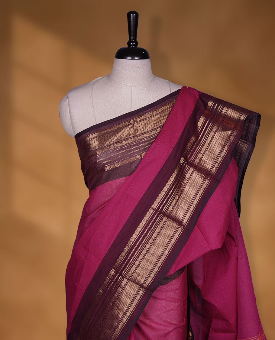 Magenta colour chettinad cotton saree featuring plain body, contrast brown colour with traditional gold zari border paired with matching blouse.