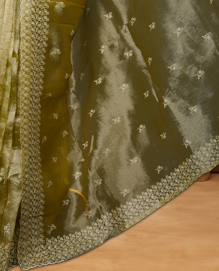 Pastel olive colour organza saree featuring white thread embroidery motifs on body and thread detailing on the border and paired matching blouse.