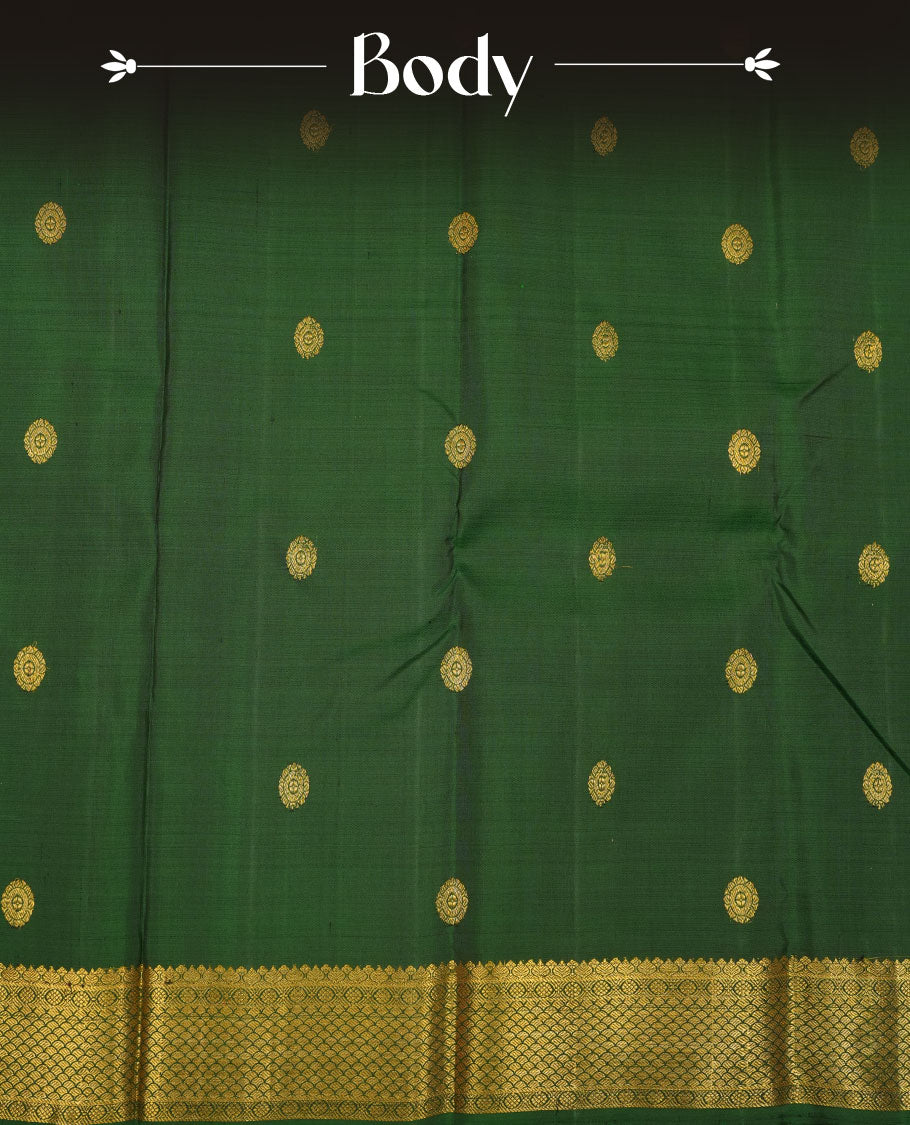 Bottle green pure traditional Kancheepuram silk saree adorned with gold zari chakra motifs across the body, featuring elegant gold zari traditional borders, beautifully paired with a matching blouse piece.