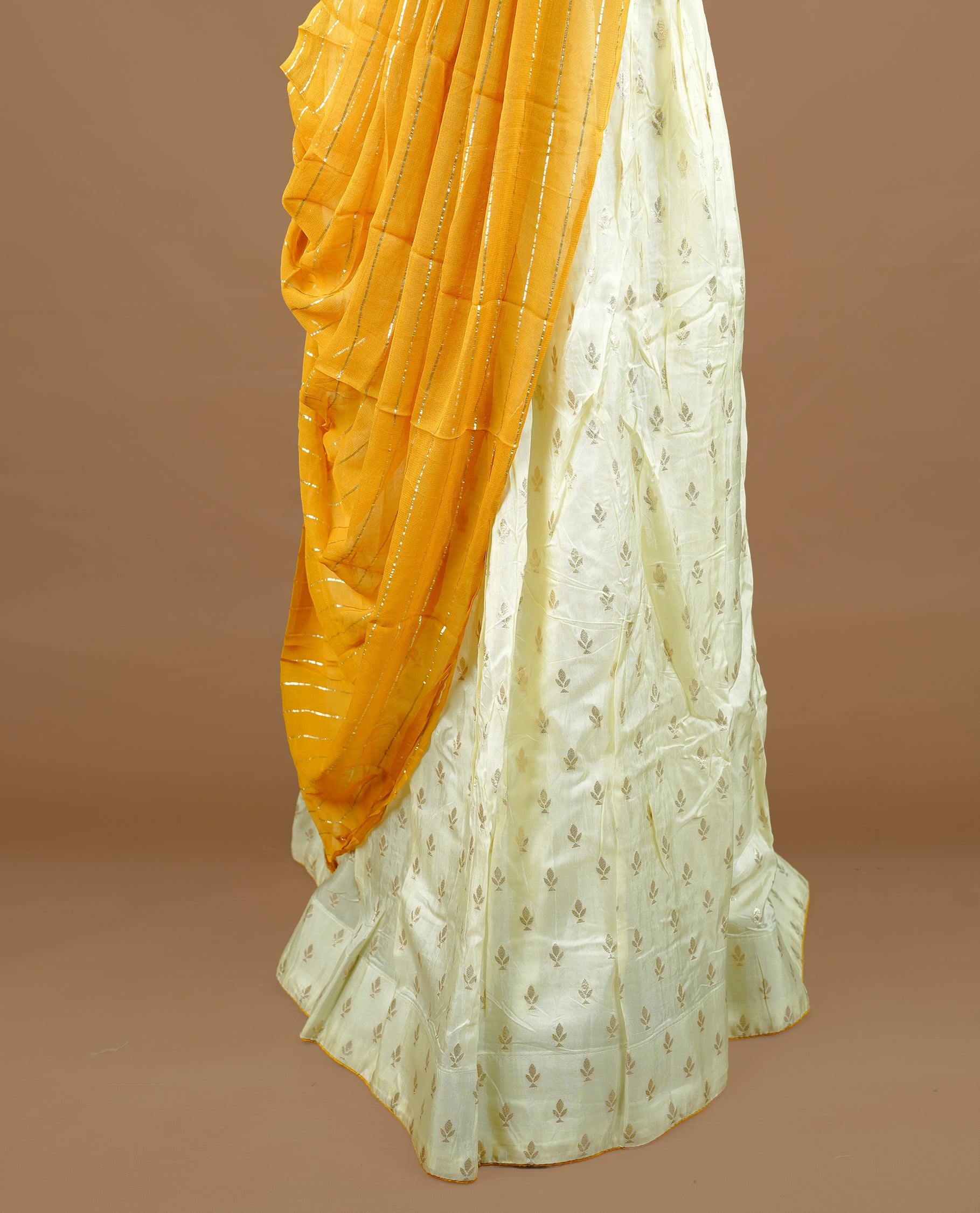 Off white colour semi stitched half saree featuring elegant zari buttas on the body, and contrast mustard colour with striped dupatta,paired with matching blouse piece.