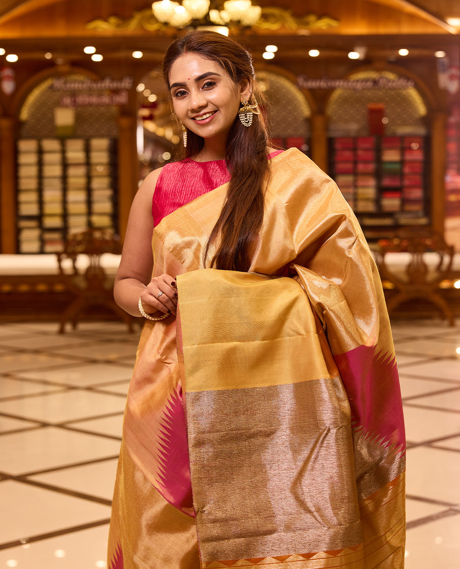 Elegant golden beige colour Kancheepuram silk saree featuring subtle woven geometric highlights with soft pink accents, beautifully paired with a rich contrast pallu and styled with a vibrant blouse