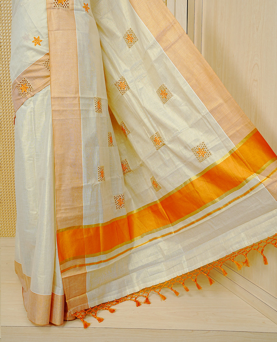 Cream Colour Tissue Kerala Saree Featuring Delicate Orange Floral Emboridery work Across The Body, Enhanced With A Light Orange Zari Border, A Vibrant Orange And Gold Zari Pallu, Finished With Orange Tassels, And A Matching Blouse Piece