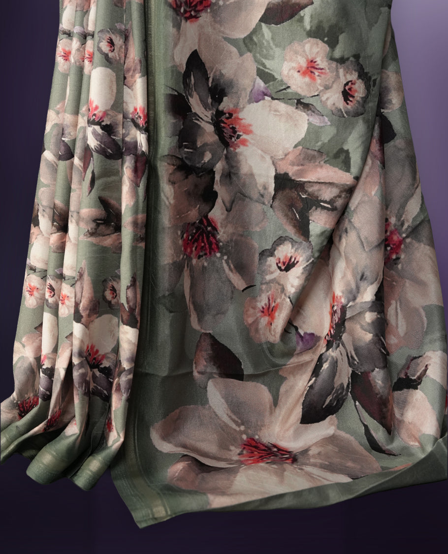 Pastel green saree adorned with elegant floral prints on the body, enhanced with a subtle matching border, complemented by a beautifully printed pallu featuring blooming flowers, and paired with a matching blouse.