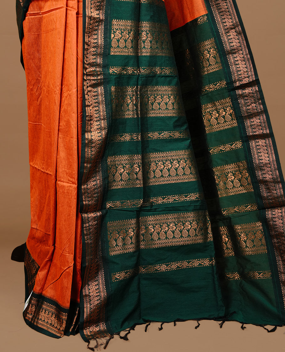 Orange colour kalyani cotton saree featuring gold zari motifs on body, highlighting contrast green colour with Antique gold zari border, paired with matching blouse piece.