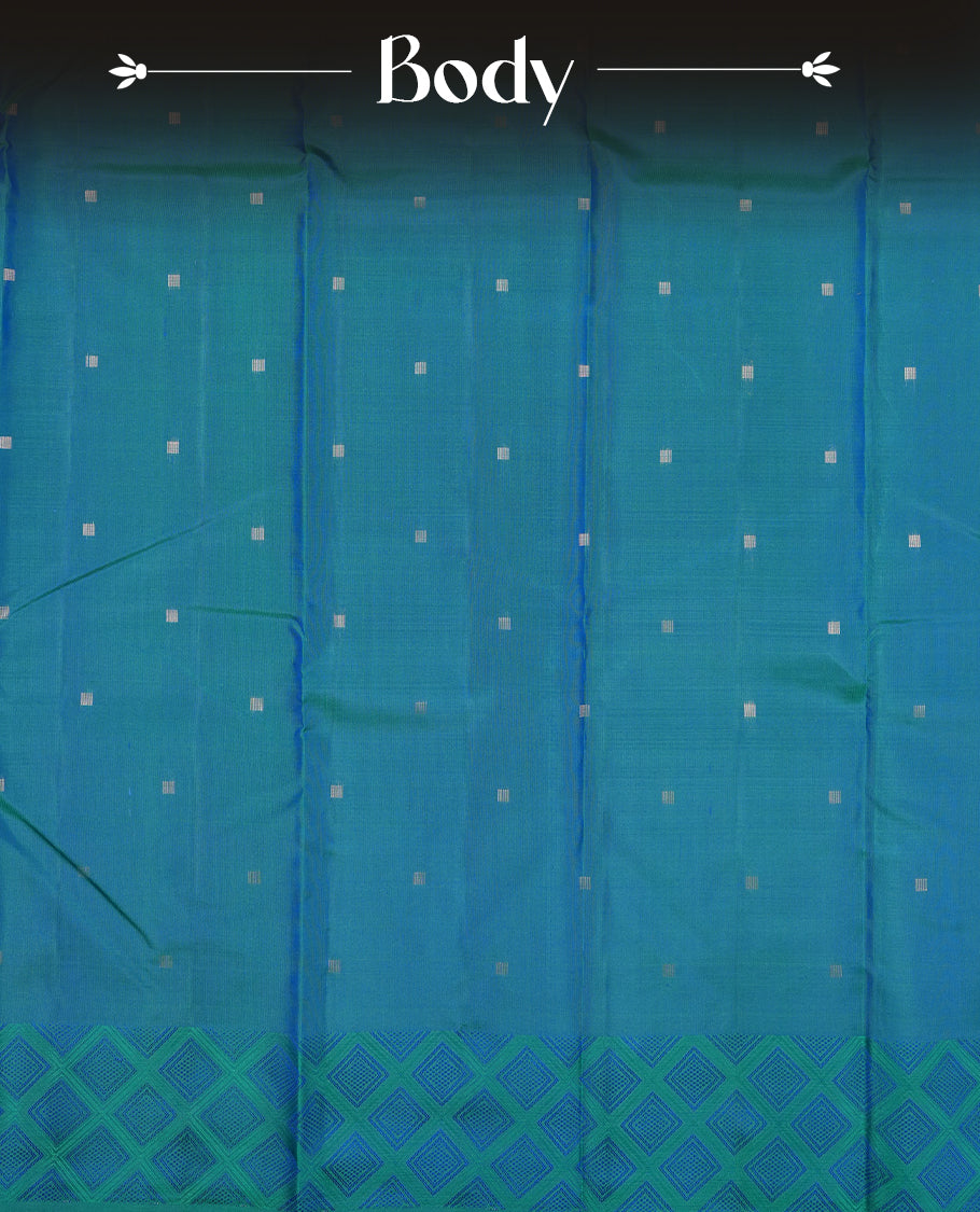 Teal colour Vasundhara silk saree adorned with all-over silver square motifs on the body, complemented by a green & blue box pattern border and paired with a matching blouse piece.