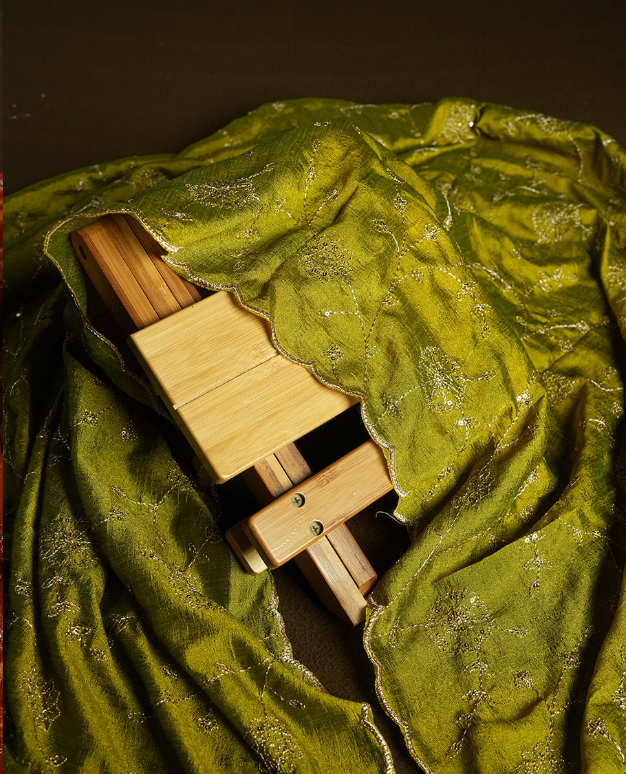 Green colour churidhar material featuring thread embroidery on the front panel, contrast Olive colour dupatta with elegant border, and matching plain bottom