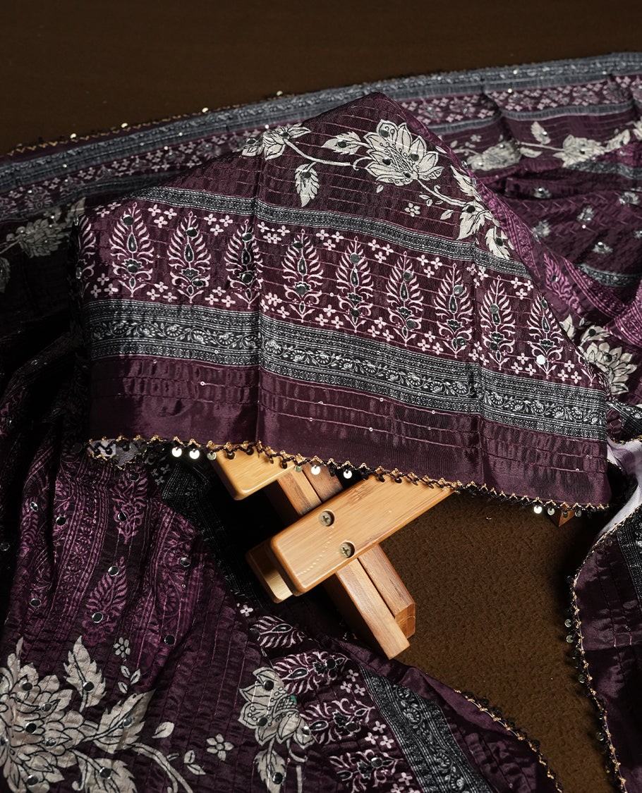 Dark purple colour churidhar material featuring Mirror and thread embroidery, foral print pattern on the self colour front panel, floral digital printed dupatta with elegant border, and matching plain bottom