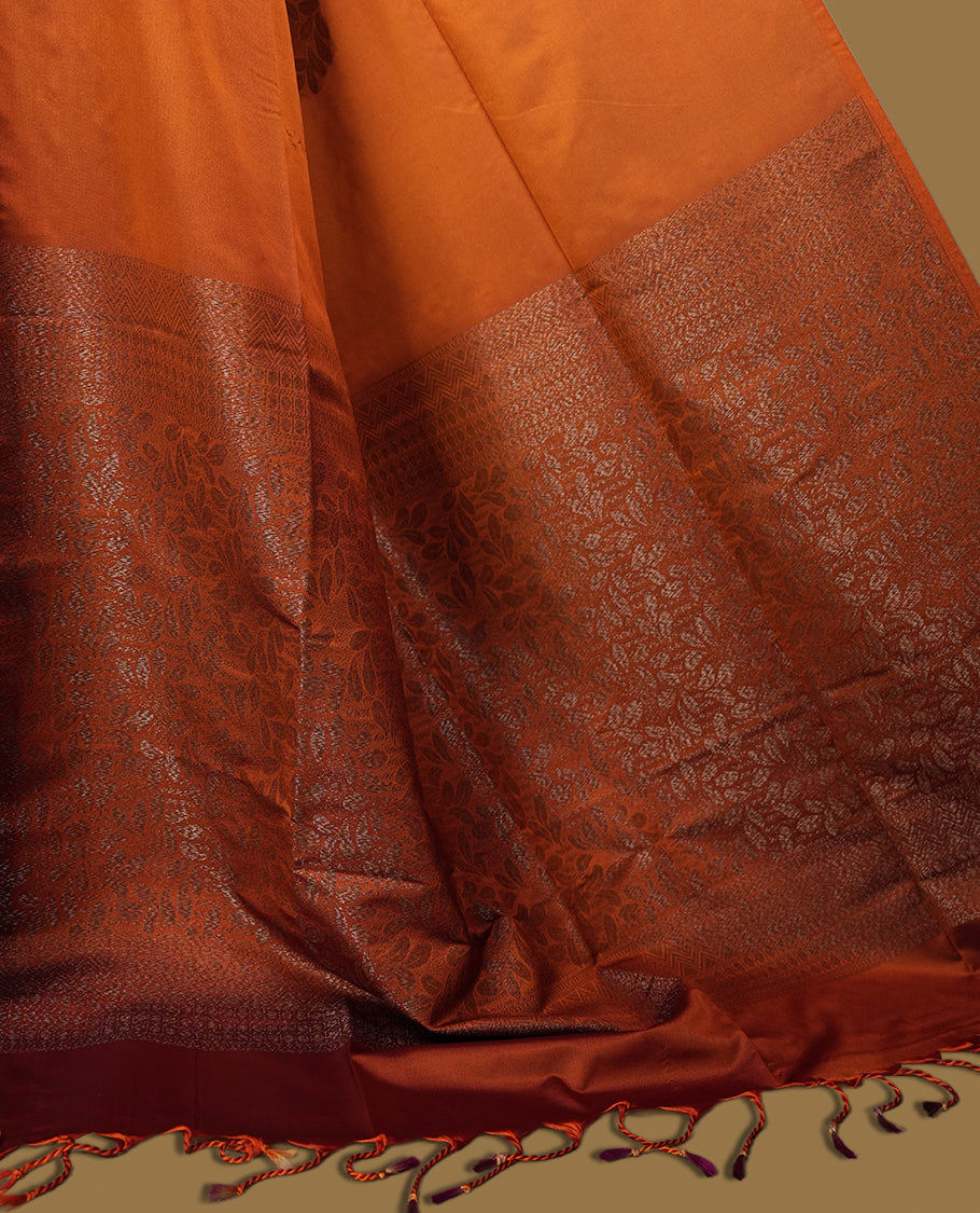Brown colour semi soft silk saree featuring intricate woven floral motifs on the body, complemented by a rich woven border and pallu with tassel finish & Comes with a matching blouse piece for an elegant look.
