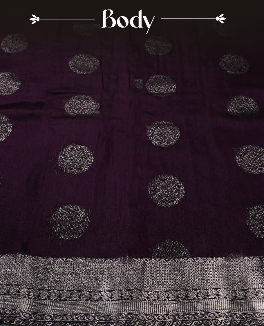 Grape colour silk cotton saree with shimmering silver zari border and intricately woven pallu, blending elegance and tradition. Paired with a matching blouse, perfect for festive celebrations and special occasions.