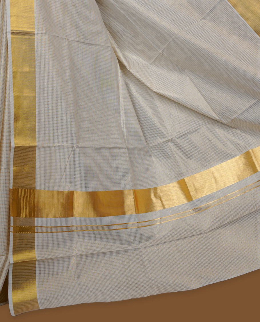 Elegant off-white colour cotton Kerala saree, highlighted with a classic gold kasavu border and subtle woven checks across the body. Finished with a clean, traditional pallu with a coordinating blouse.