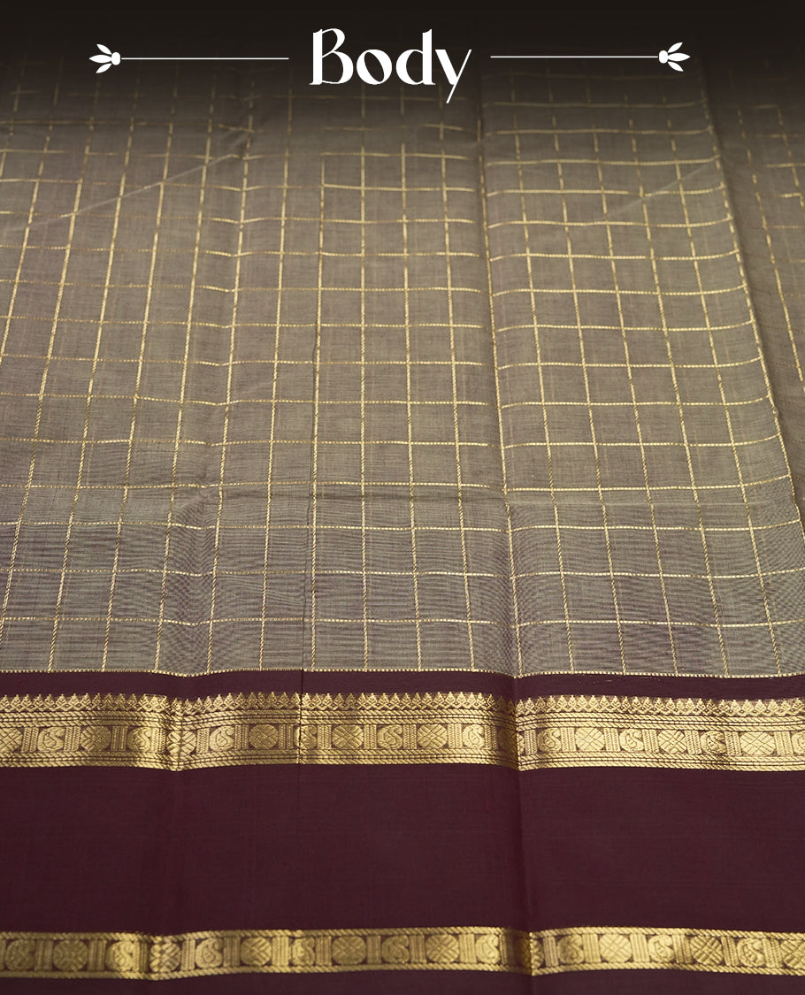 Grey colour Pure Kanchi cotton saree adorned with golden checks, complemented by a rich maroon zari border, paired with a matching blouse & A timeless blend of tradition and elegance, perfect for festive and casual wear.