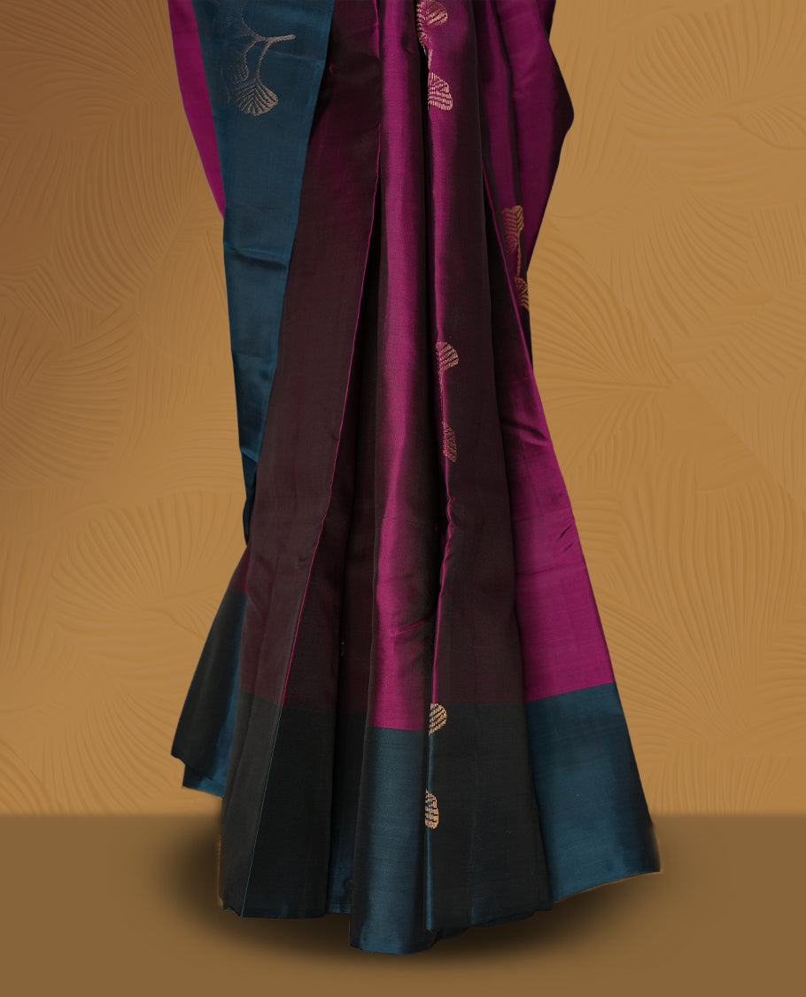 Dark magenta colour soft silk saree adorned with golden zari motifs, enhanced by a deep peacock zari border and pallu with delicate detailing & paired with a matching blouse.