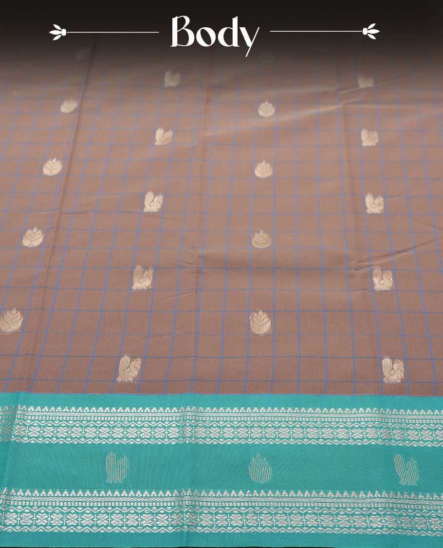 Beige Colour silk cotton saree with checkered body, scattered silver zari leaf buttas, ornate silver zari borders in teal green, diamond lattice pallu with temple motifs, teal green blouse with matching border.