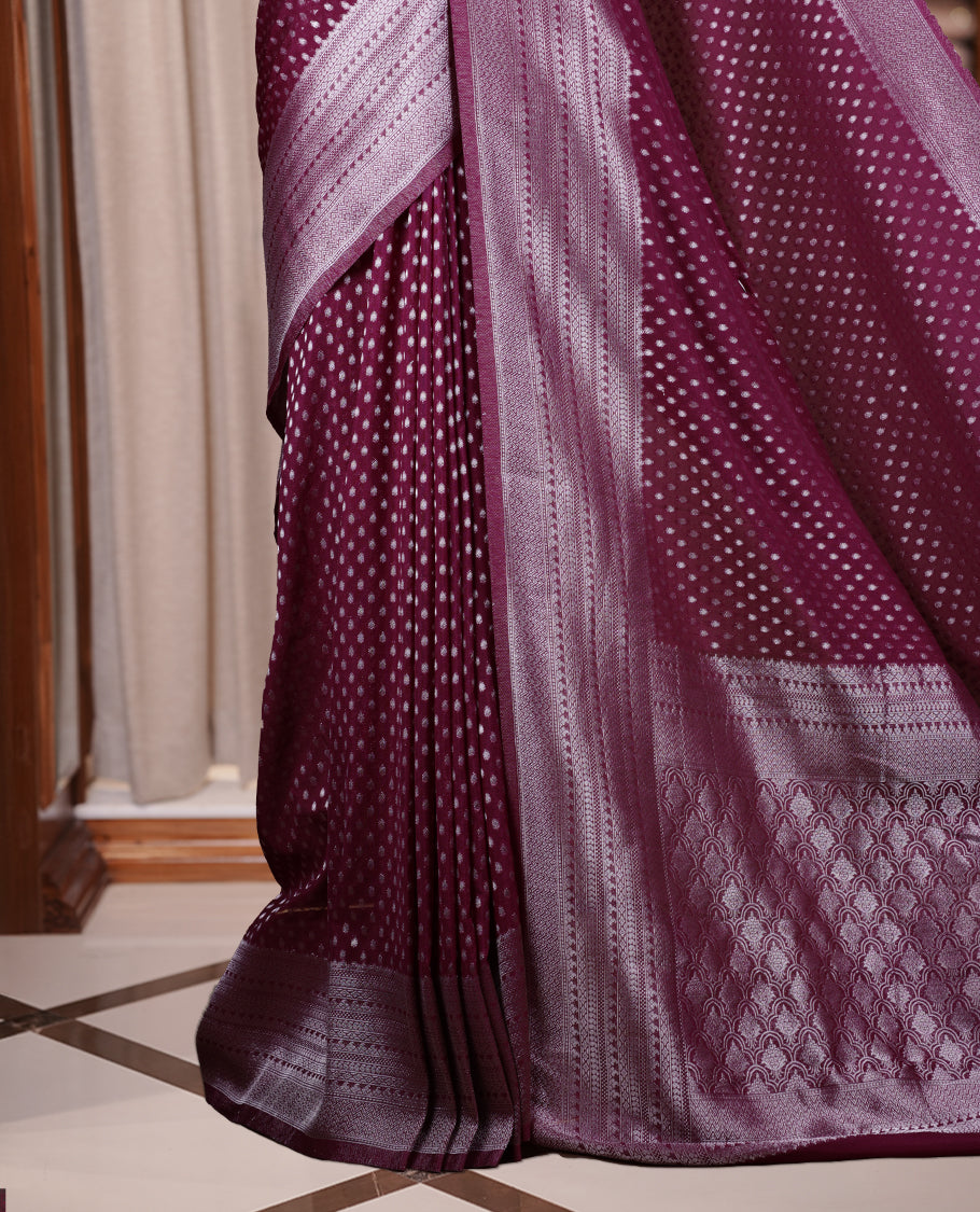 Wine colour Banarasi silk saree featuring intricate zari weaving and a soft silk texture, Adorned with silver motifs on the body, complemented by a rich Banarasi border and pallu & Comes with a matching blouse.