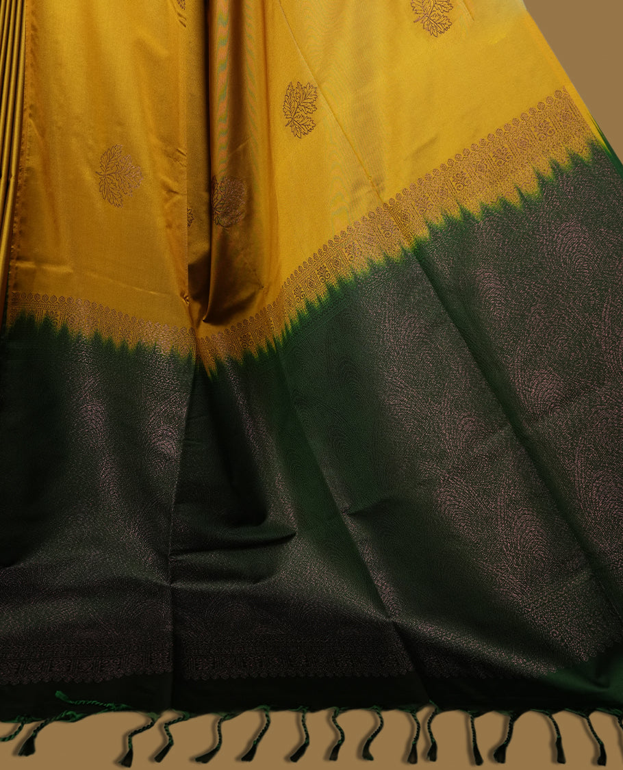 Deep mustard yellow colour semi soft silk saree, beautifully designed with woven leaf motifs & The look is enhanced by a rich contrast green pallu, paired with a matching blouse.