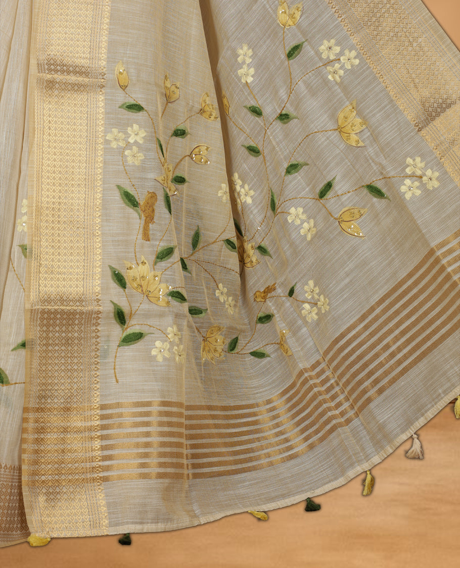 Beige colour linen silk saree featuring hand brushed colour with Floral & birds printed pattern on body, gold zari woven geometric design border with self colour pallu and comes with a matching blouse