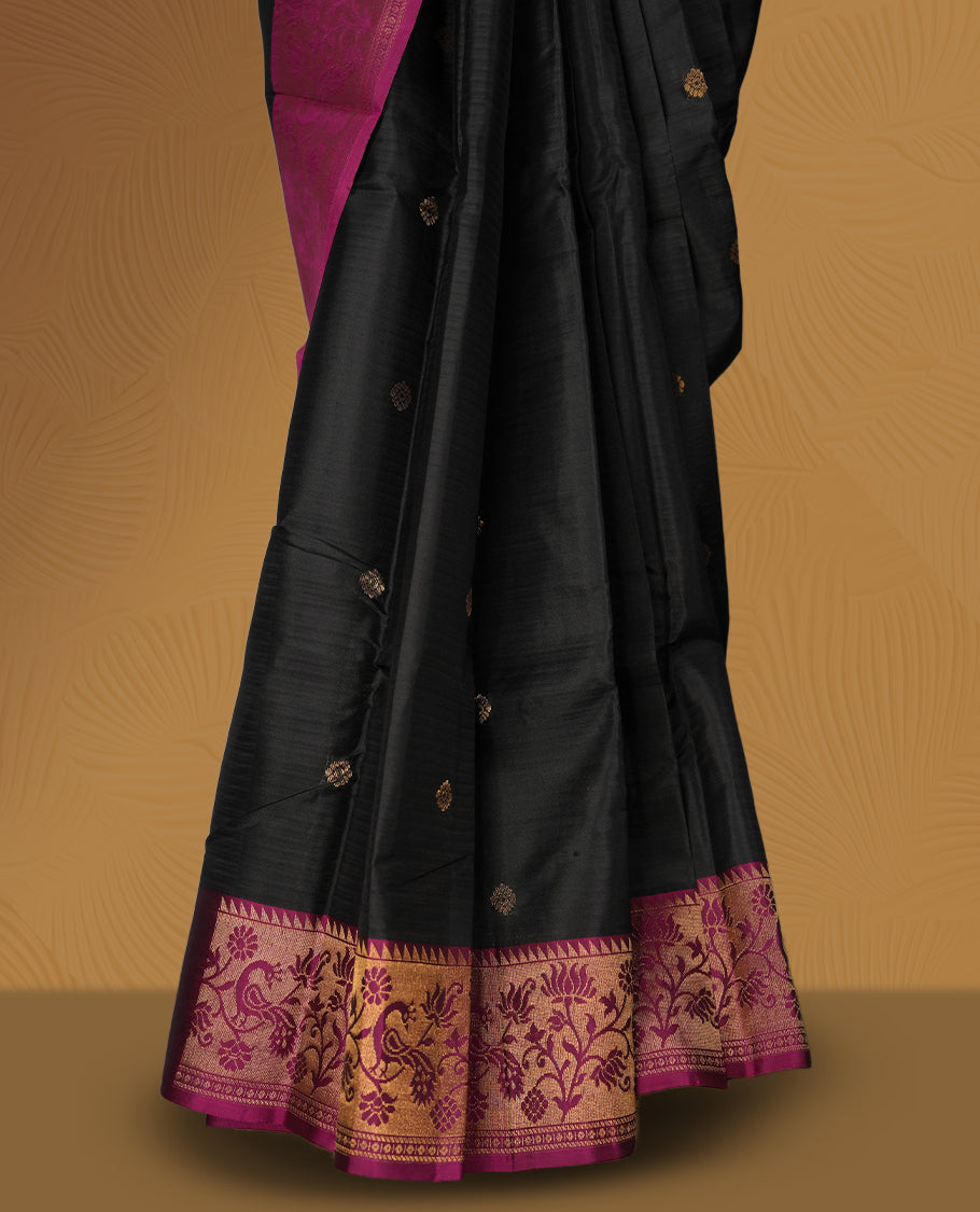 Black colour soft silk saree adorned with golden buttas, enhanced by a deep magenta border and pallu featuring intricate zari floral designs & Paired with a matching blouse.